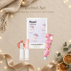 Wichtel-Set: rom&nd Glasting Melting Balm, Frudia My Orchard Hand Cream und MISSHA Airy Fit Sheet Mask Pearl auf winterlichem Hintergrund